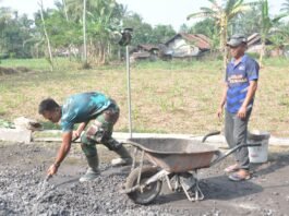 Kompak Bersama Warga, Prada Dika Arya Angkut Material untuk Percepatan Pengecoran